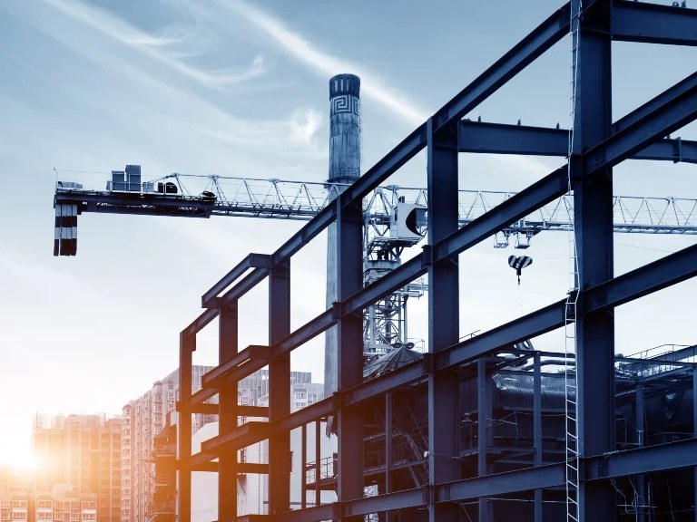 Steel frame of a building under construction with a tower crane